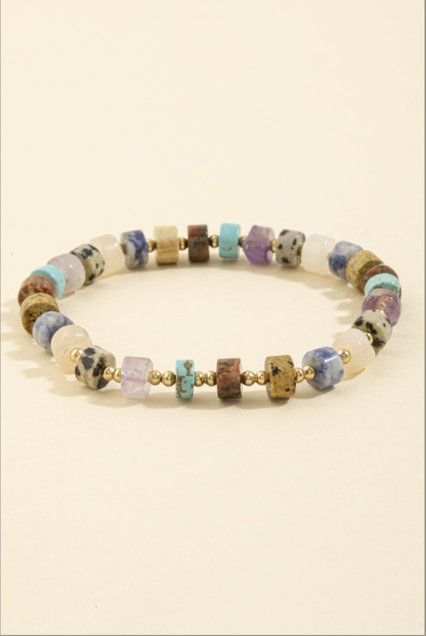 Stretch bracelet featuring multicolor semi-precious stone beads with gold spacer beads.