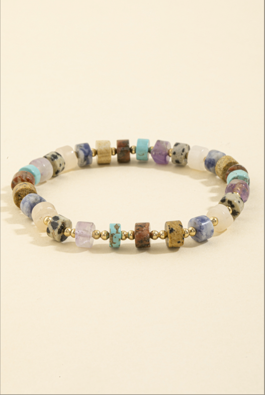 Stretch bracelet featuring multicolor semi-precious stone beads with gold spacer beads.