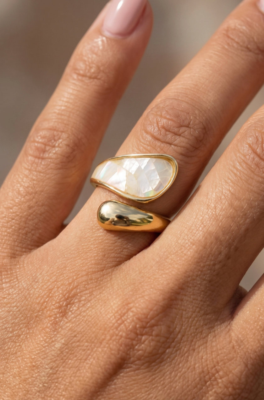 Gold wrap ring with iridescent ivory shell inlay and asymmetrical crossover design.