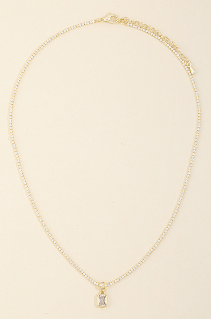 Gold pavé tennis necklace with emerald-cut cubic zirconia pendant in a bezel setting.