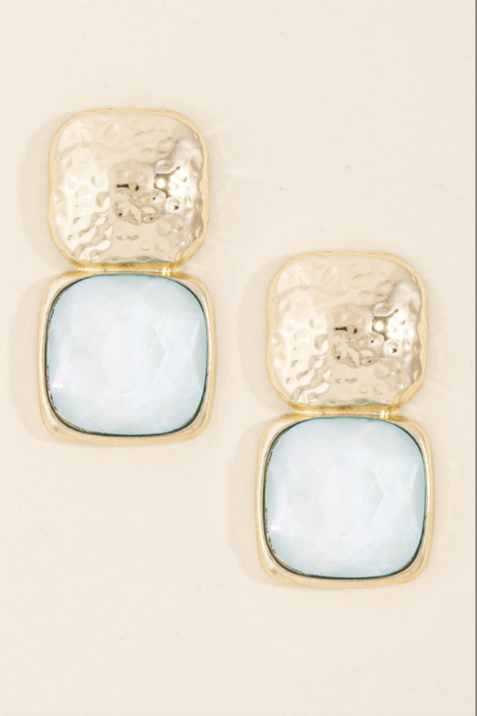 Gold hammered drop earrings with faceted sky blue square resin stones in a bezel setting.