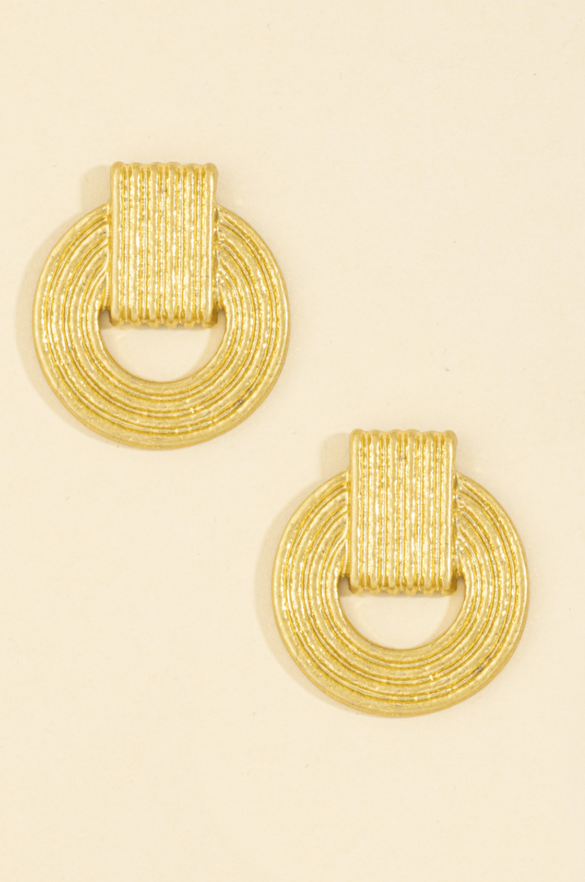 Gold-tone fluted doorknocker stud earrings with an open circular textured design.
