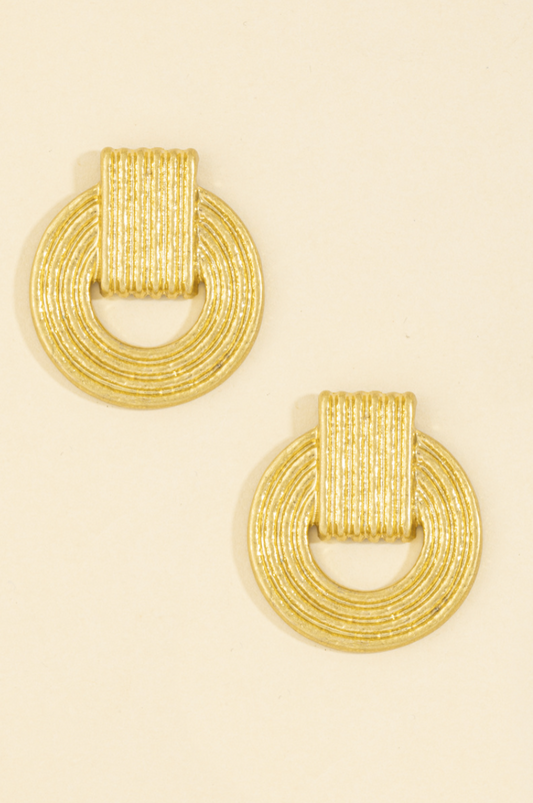 Gold-tone fluted doorknocker stud earrings with an open circular textured design.