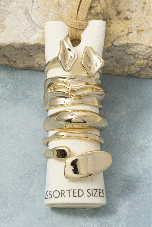 Five-piece gold molten stacking ring set featuring organic sculptural bands with a polished finish.