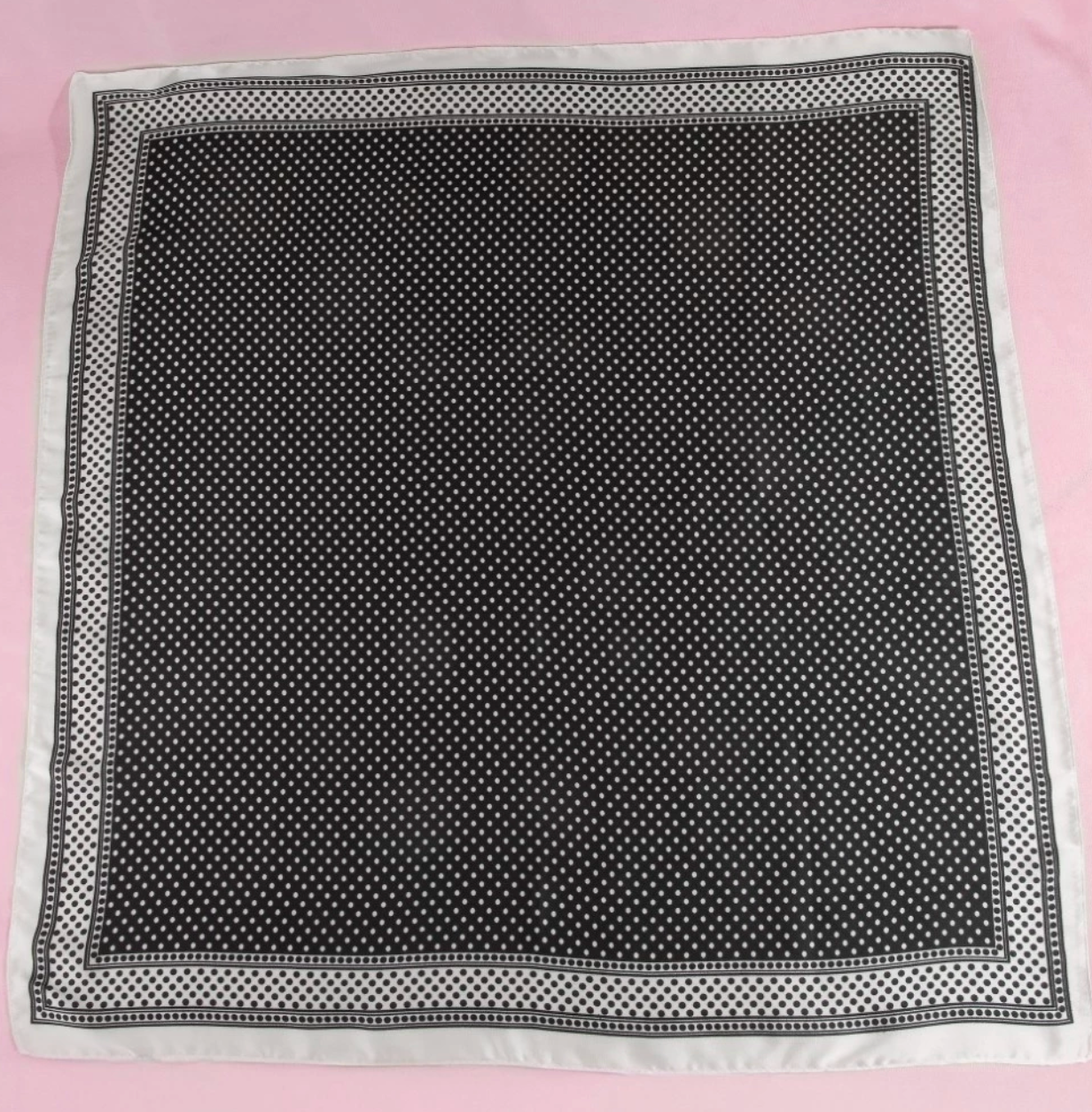 Black square scarf with a classic white polka dot pattern and coordinating white border.