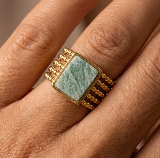 Gold-tone stainless steel ring with a five-row beaded band and a rectangular green natural stone centerpiece.
