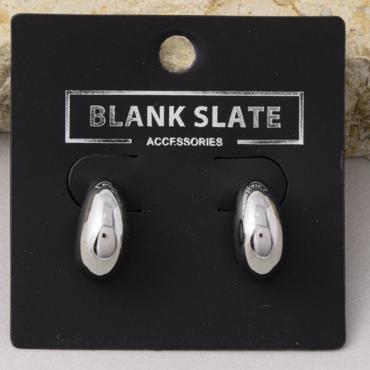 Small polished silver stainless steel teardrop huggie earrings with a sleek mirror finish.