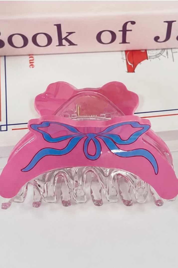 Hot pink coquette hair claw clip with cream illustrated ribbon bow and clear resin teeth.