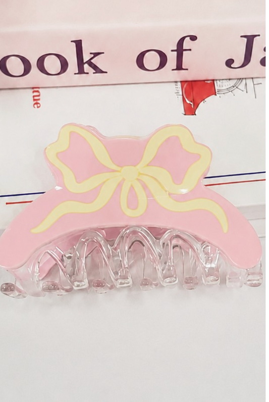Light pink coquette hair claw clip with cream illustrated ribbon bow and clear resin claw.