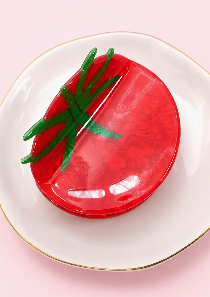 Zesty Claw Clip Tomato featuring glossy marbled red acetate in a tomato shape with dimensional dark green leaf detailing.