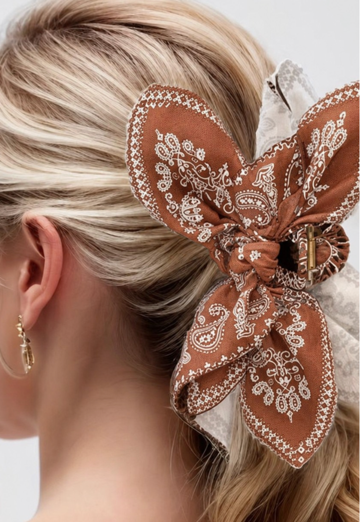 Taylor Paisley Claw Clip Brown featuring an oversized brown and cream paisley bow hair clip styled in a blonde ponytail.