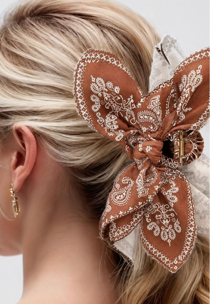 Taylor Paisley Claw Clip Brown featuring an oversized brown and cream paisley bow hair clip styled in a blonde ponytail.