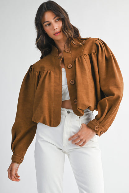 Model wearing a cropped brown faux suede jacket with a bubble hem and button-down front