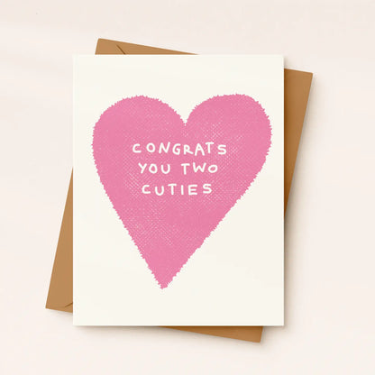 Greeting card with pink heart and text 'Congrats you two cuties' on a white background