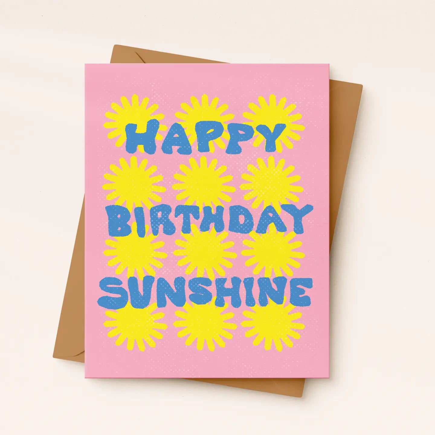 Pink birthday card with yellow sunflowers and blue text on a beige background