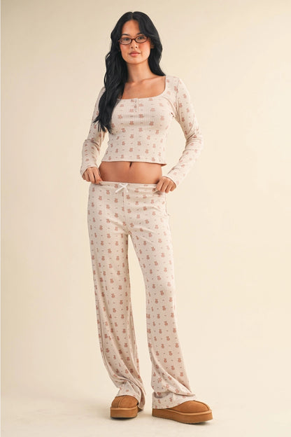 Woman wearing a matching top and pants set on a beige background