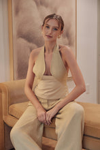 Load image into Gallery viewer, Model wearing gold mixed-media halter top with open back and tailored neckline