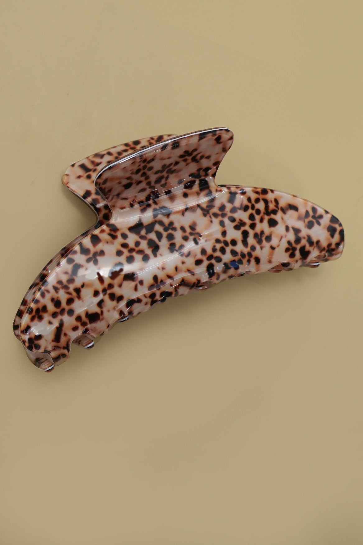Leopard print hair clip on a beige background