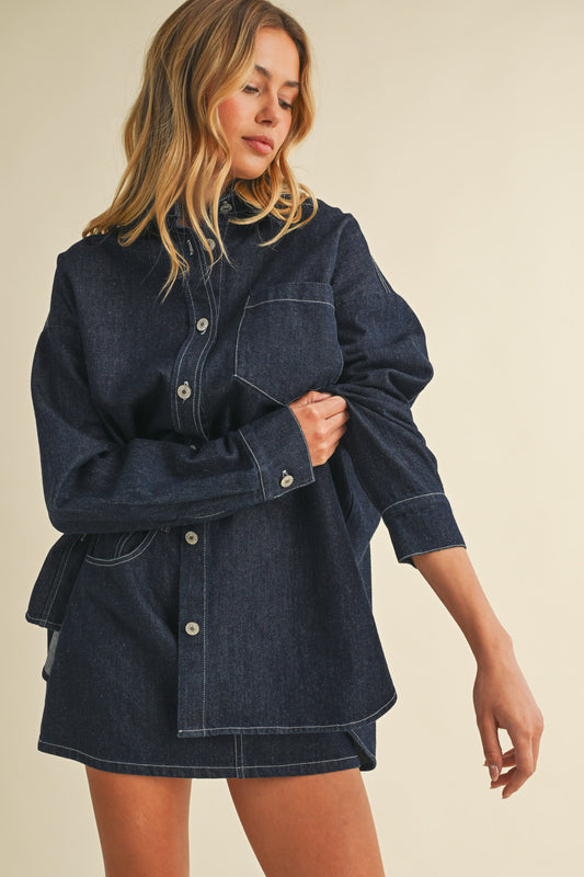 Model wearing dark-wash oversized denim shacket with matching mini skirt