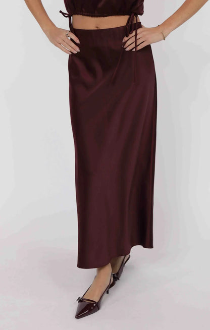 Model wearing wine satin bias cut midi skirt with sleek drape