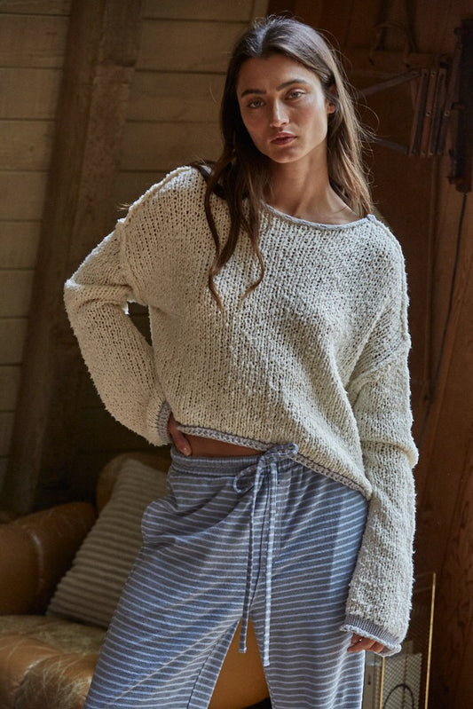 Model wearing the Dreamscape Sweater in cream with scoop neck and contrast hem details