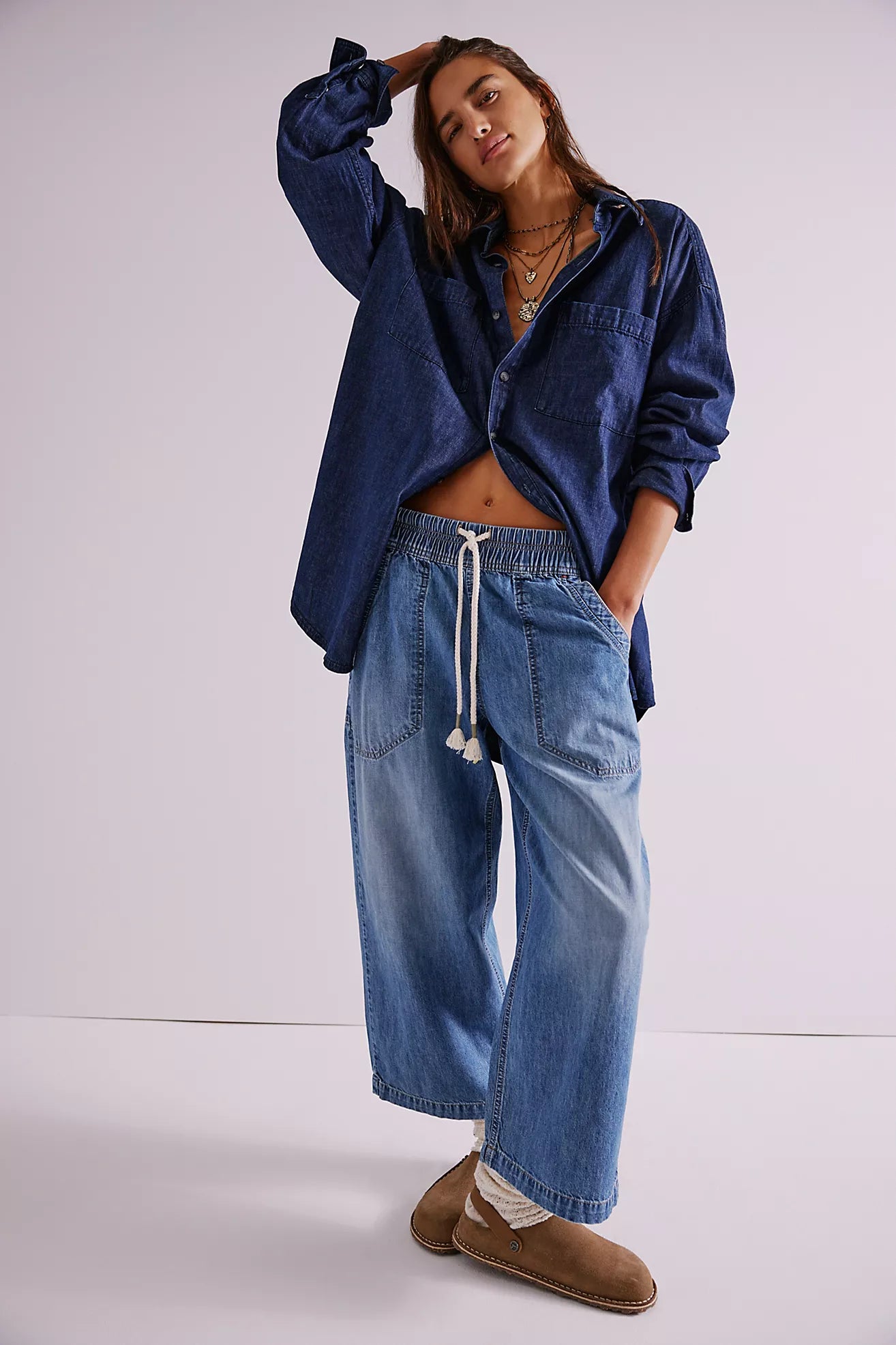 Woman wearing a blue denim jacket and jeans on a white background