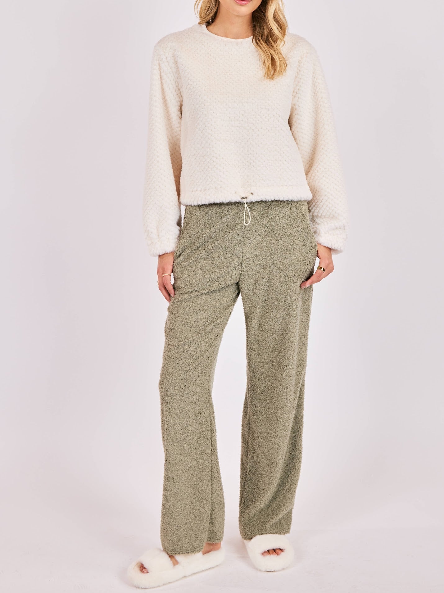 Woman wearing cream fuzzy knit top with adjustable drawstring hem