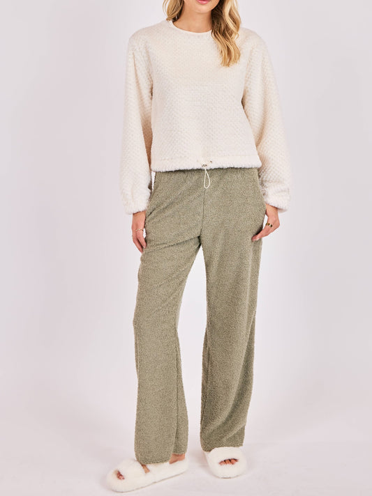 Woman wearing cream fuzzy knit top with adjustable drawstring hem