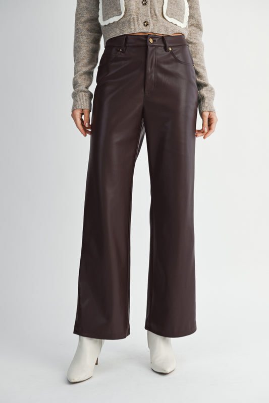 Model wearing high-waisted faux leather straight-leg pants with a sleek finish