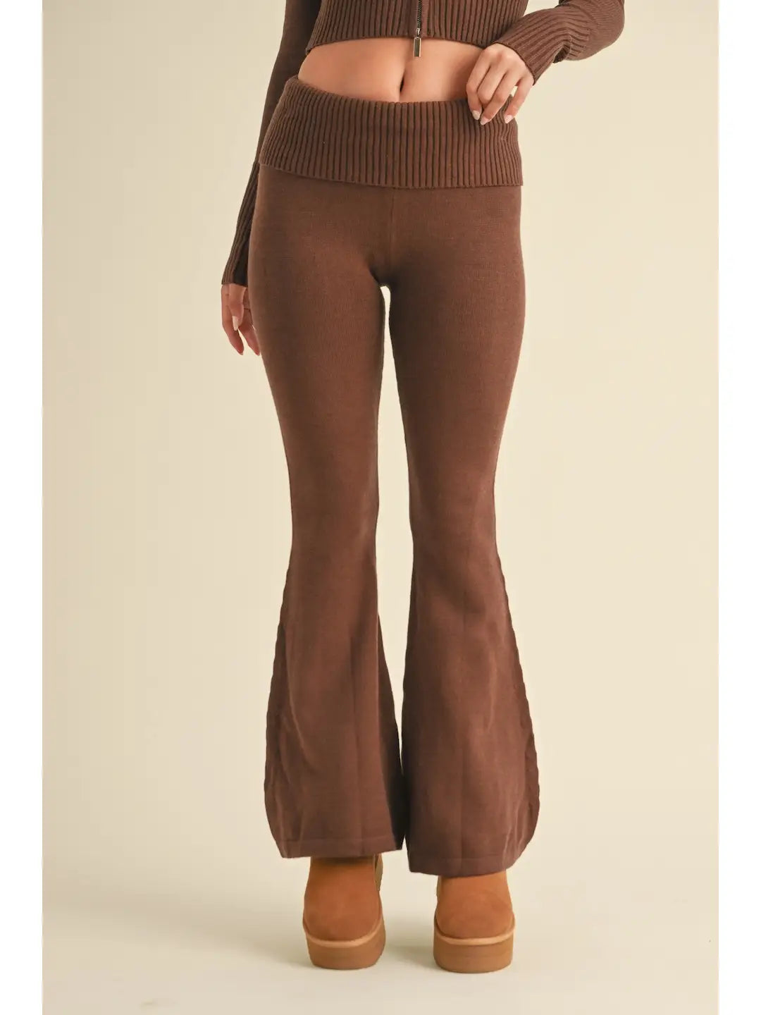 Brown ribbed knit top and flared pants on a beige background