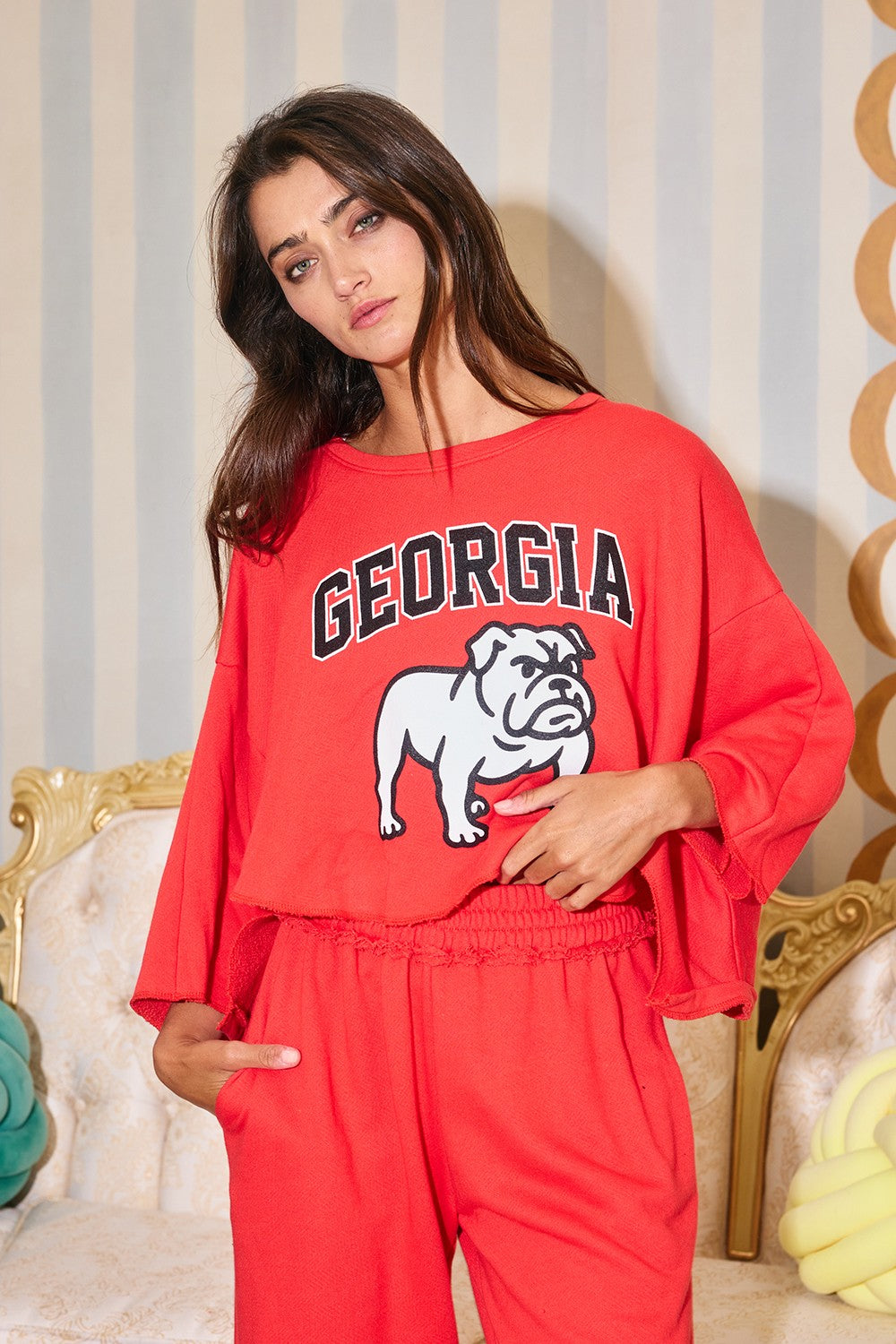 Model wearing red cropped Georgia Bulldog graphic sweatshirt with relaxed wide sleeves
