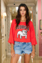 Load image into Gallery viewer, Woman wearing a red &#39;Georgia&#39; sweatshirt with a bulldog graphic in a hallway.