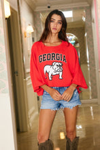 Load image into Gallery viewer, Woman wearing a red &#39;Georgia&#39; sweatshirt with a bulldog graphic in a hallway.