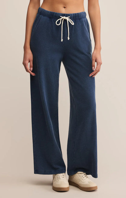 Woman wearing indigo knit denim pants with drawstring waist and side pockets