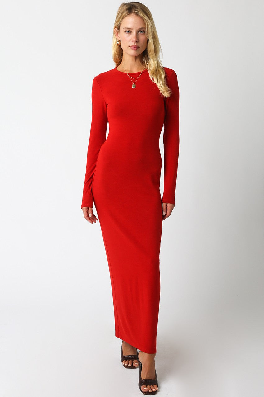 Woman wearing a red long sleeve knit maxi dress with a round neckline and slim fitted silhouette paired with heels.
