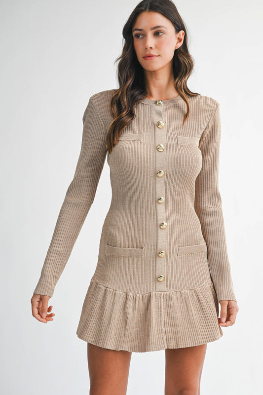 Woman wearing a beige ribbed dress with buttons on a white background