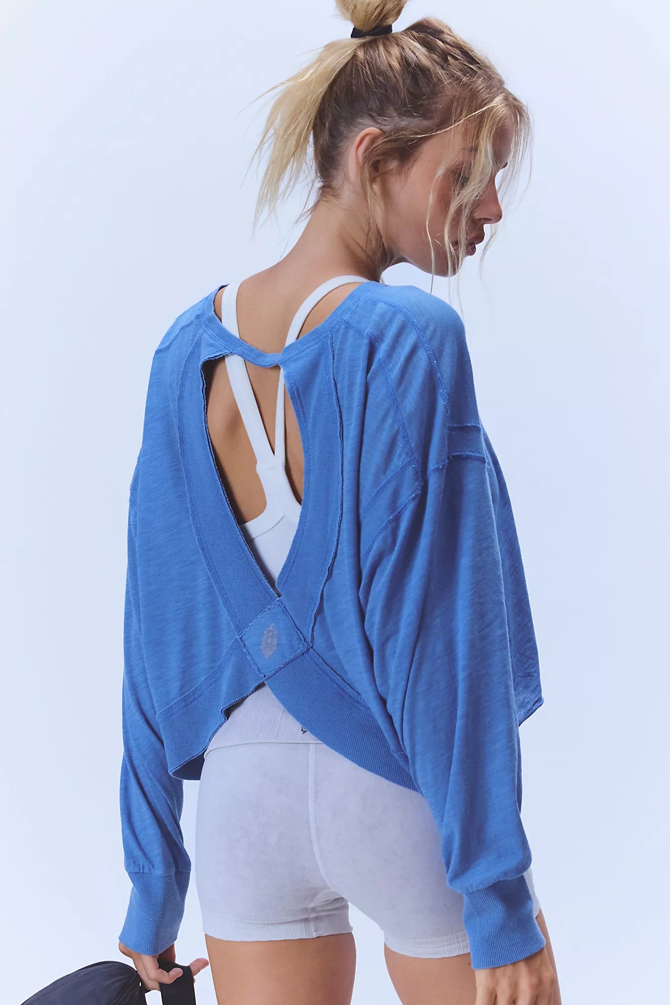 Model wearing blue My Time Layer cropped open back sweatshirt over white sports bra