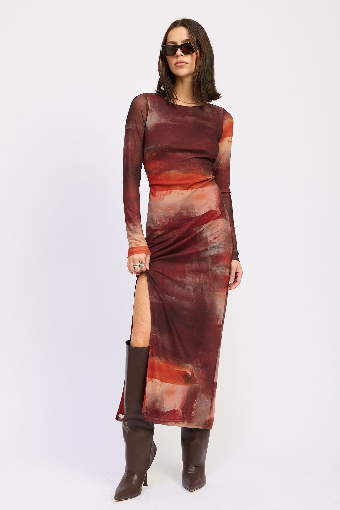 Model wearing Ember Skies Mesh Maxi Dress with abstract rust print, long sleeves, and high slit