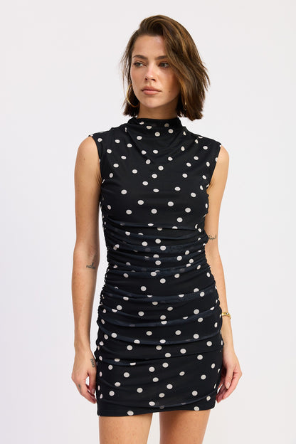 Woman wearing a black polka dot dress on a white background