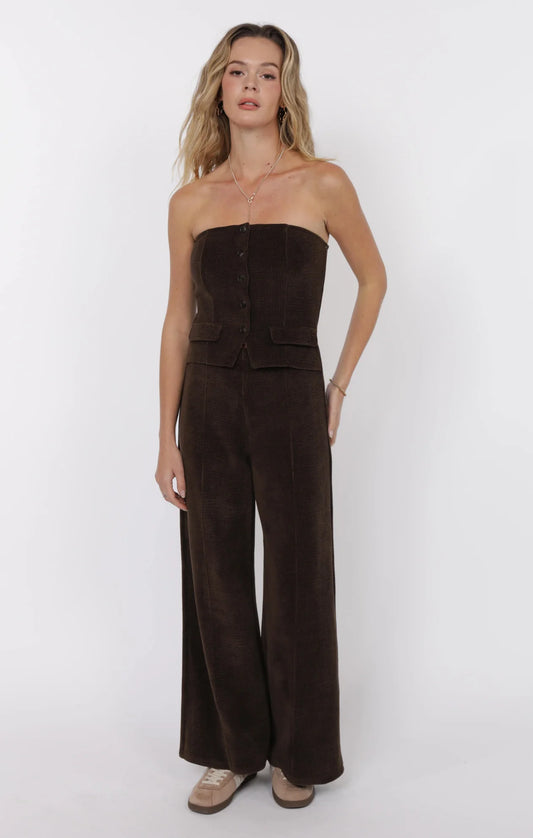 Model wearing strapless brown corduroy tube jumpsuit with wide-leg pants