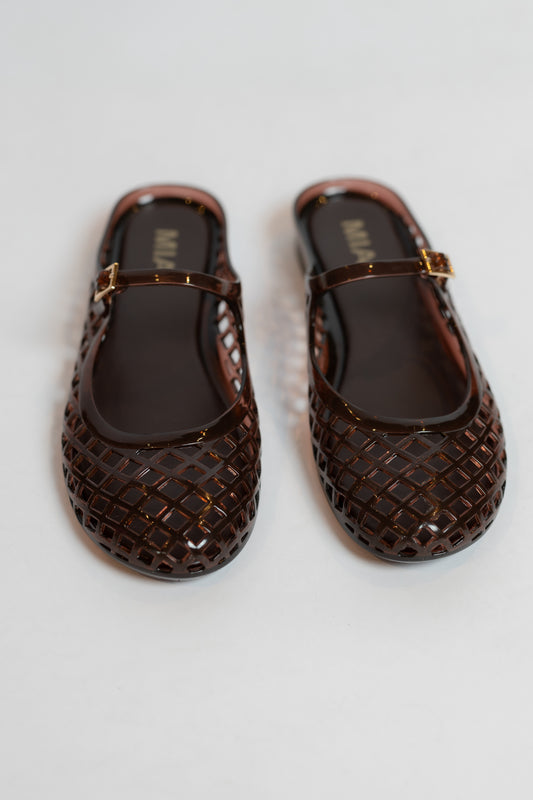 Pair of brown jelly slip on shoes on a white background