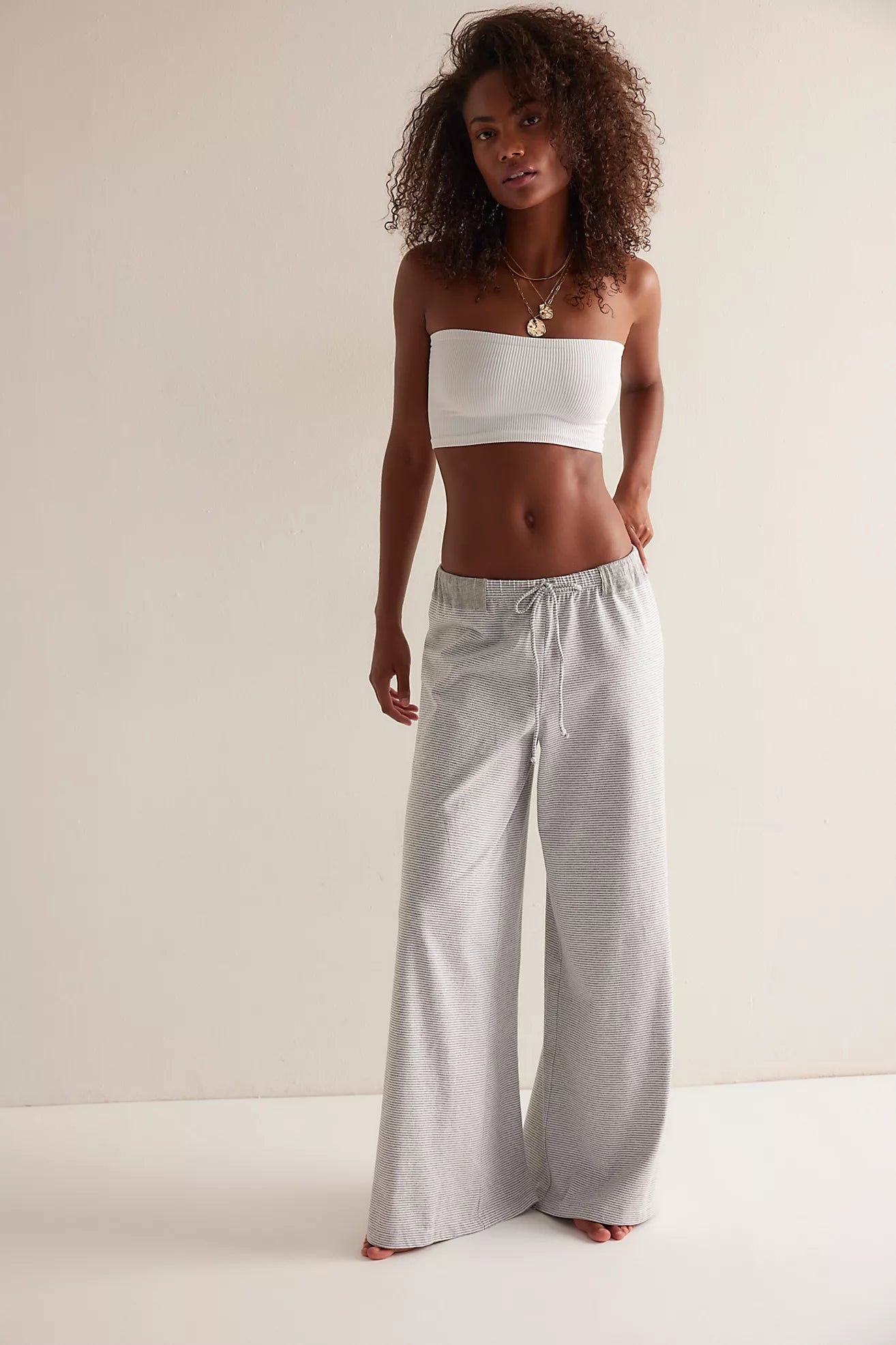 Model wearing gray micro-stripe wide-leg lounge pants with drawstring waistband