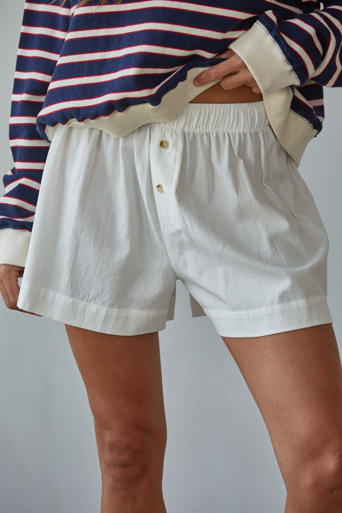 White woven cotton shorts with elastic waistband and button-down detail