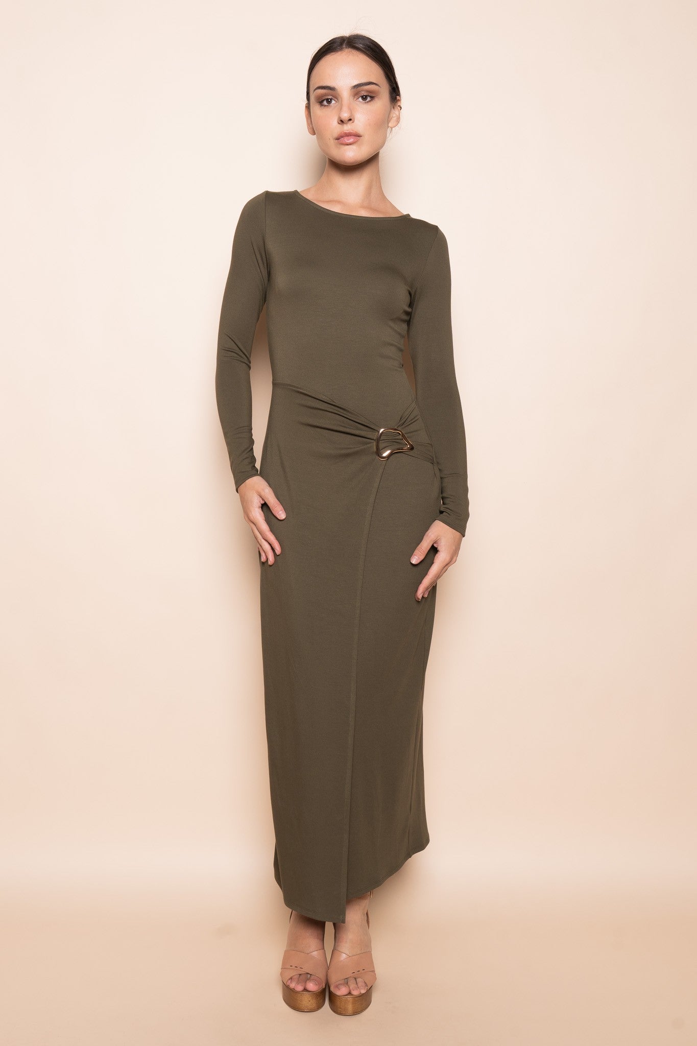 Woman wearing sculpted buckle maxi dress in olive with wrap panel and gold buckle