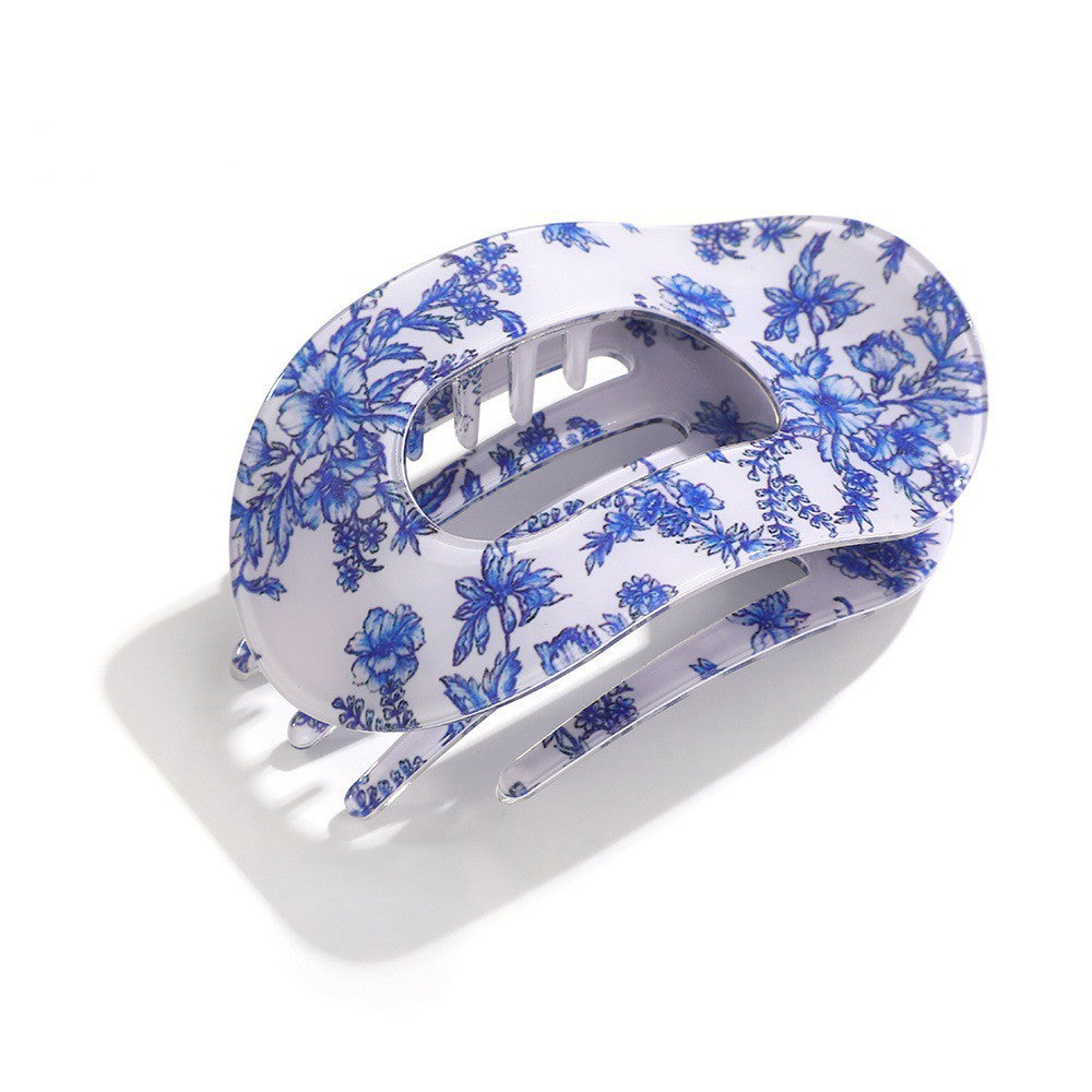 White hair clip with blue floral pattern on a white background