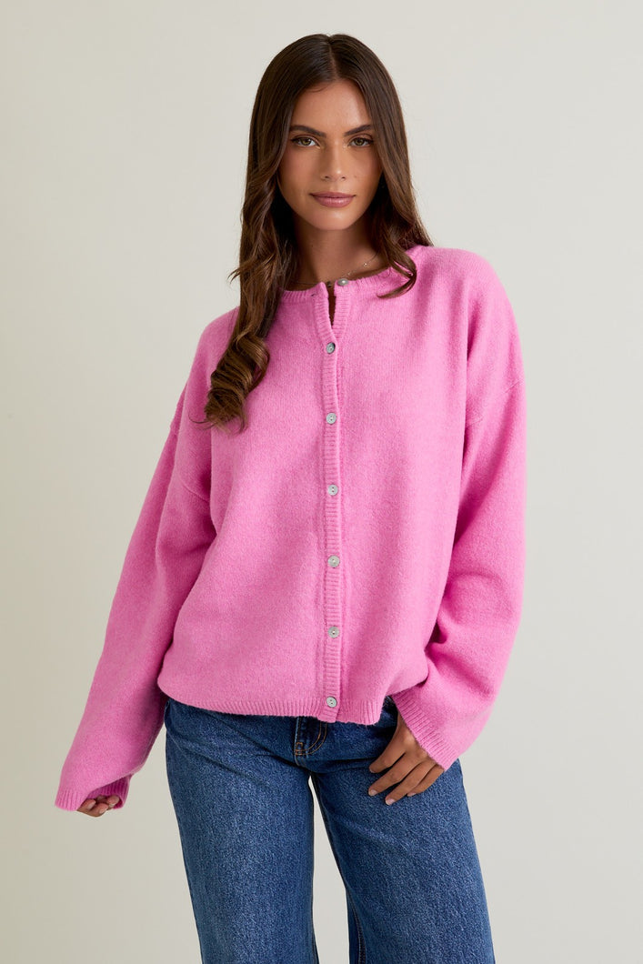 Model wearing Sweet Charm Button Cardigan in pink, featuring long sleeves, crew neckline, and button-down front.