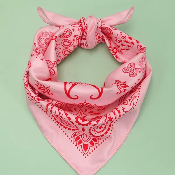 Pink bandana with red patterns on a light green background