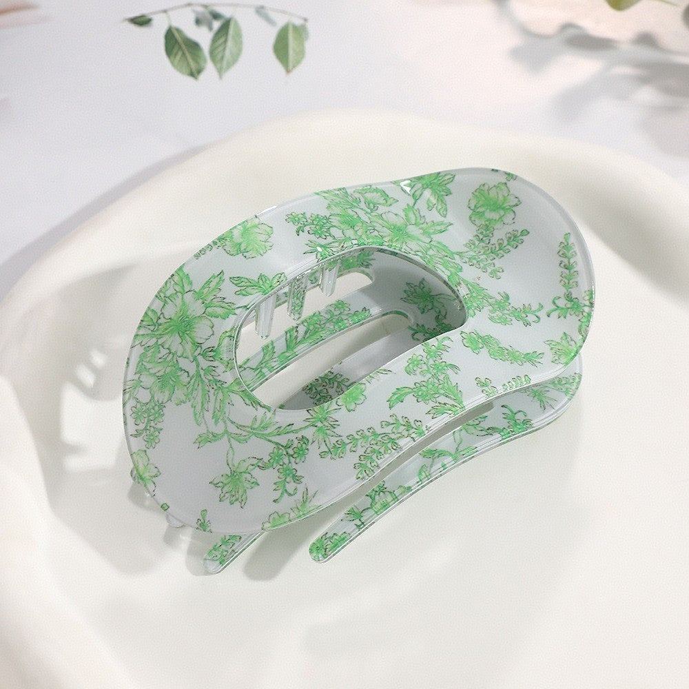 Oval lay flat hair claw clip with decorative printed pattern designed for comfortable all day hold
