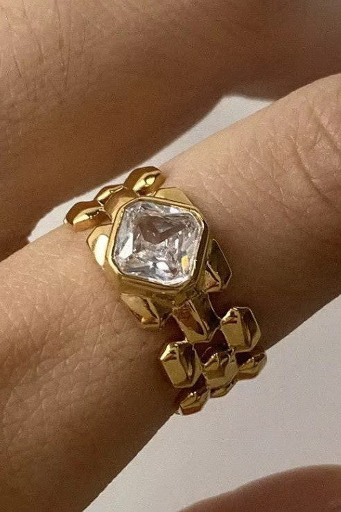 close-up of gold geometric link ring with square rhinestone centerpiece