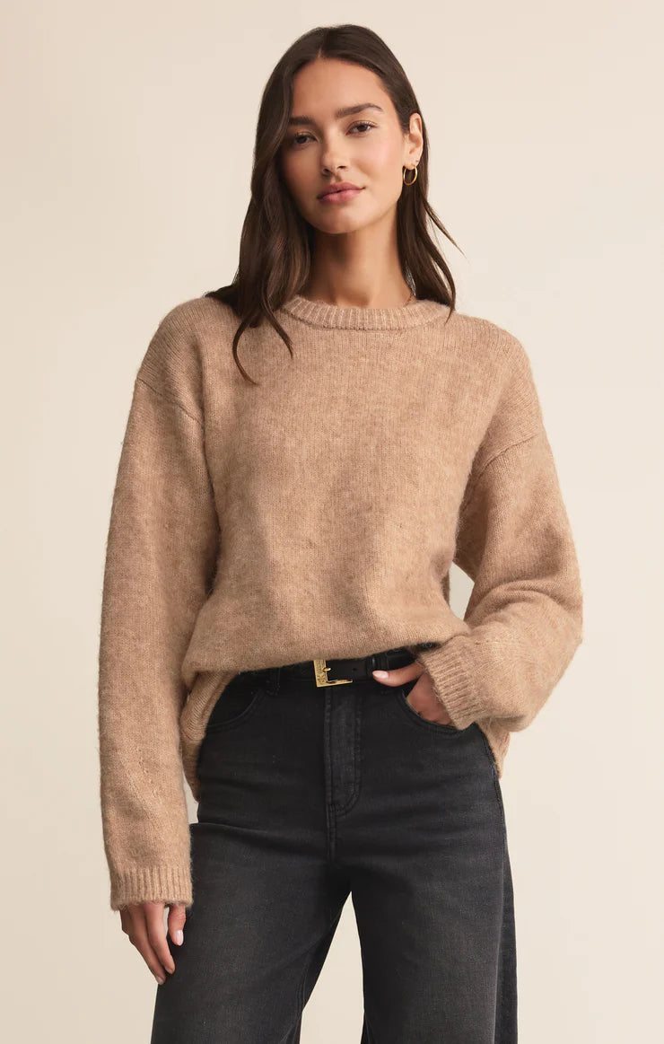 Neutral mohair-blend crewneck sweater with relaxed fit and long sleeves styled with black denim.